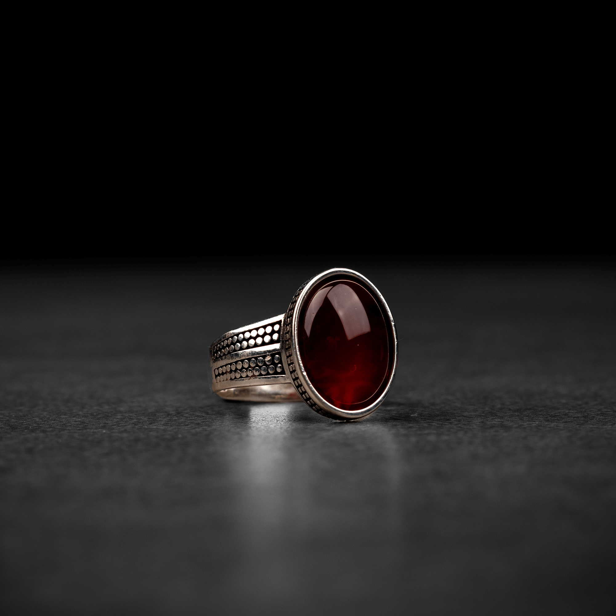 Men's silver ring decorated with a red agate stone with circular engravings