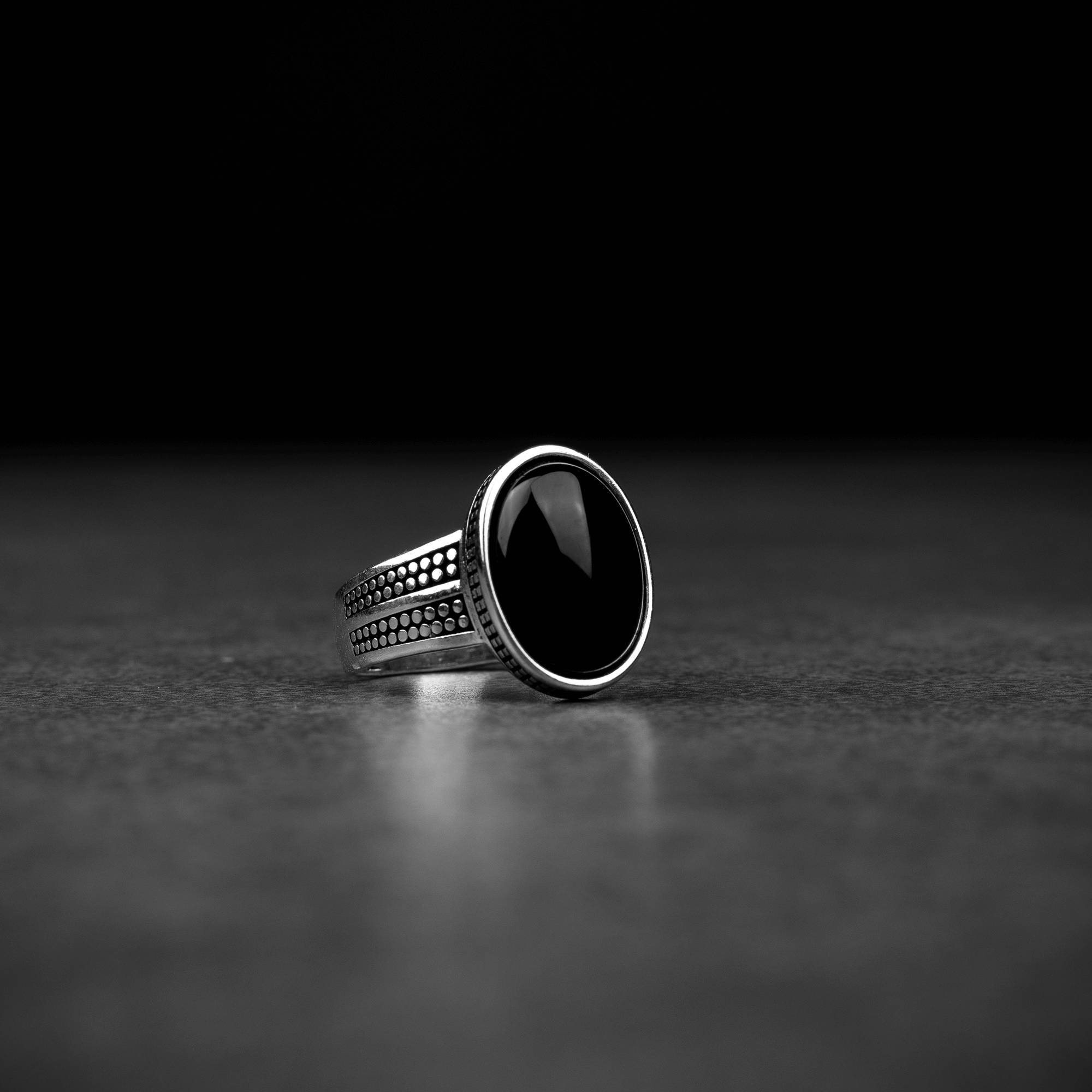 Men's silver ring decorated with black onyx stone with circular engravings
