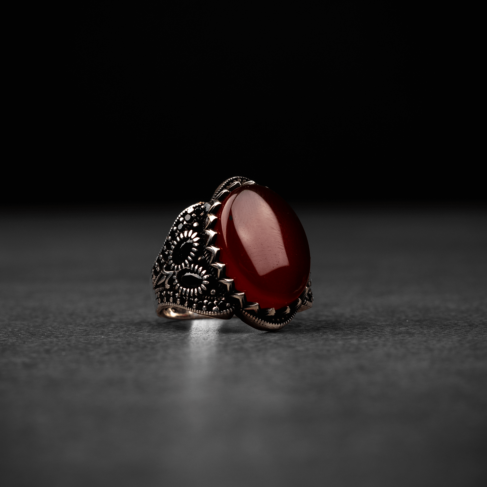 Men's silver ring decorated with a red agate stone surrounded by a geometric design