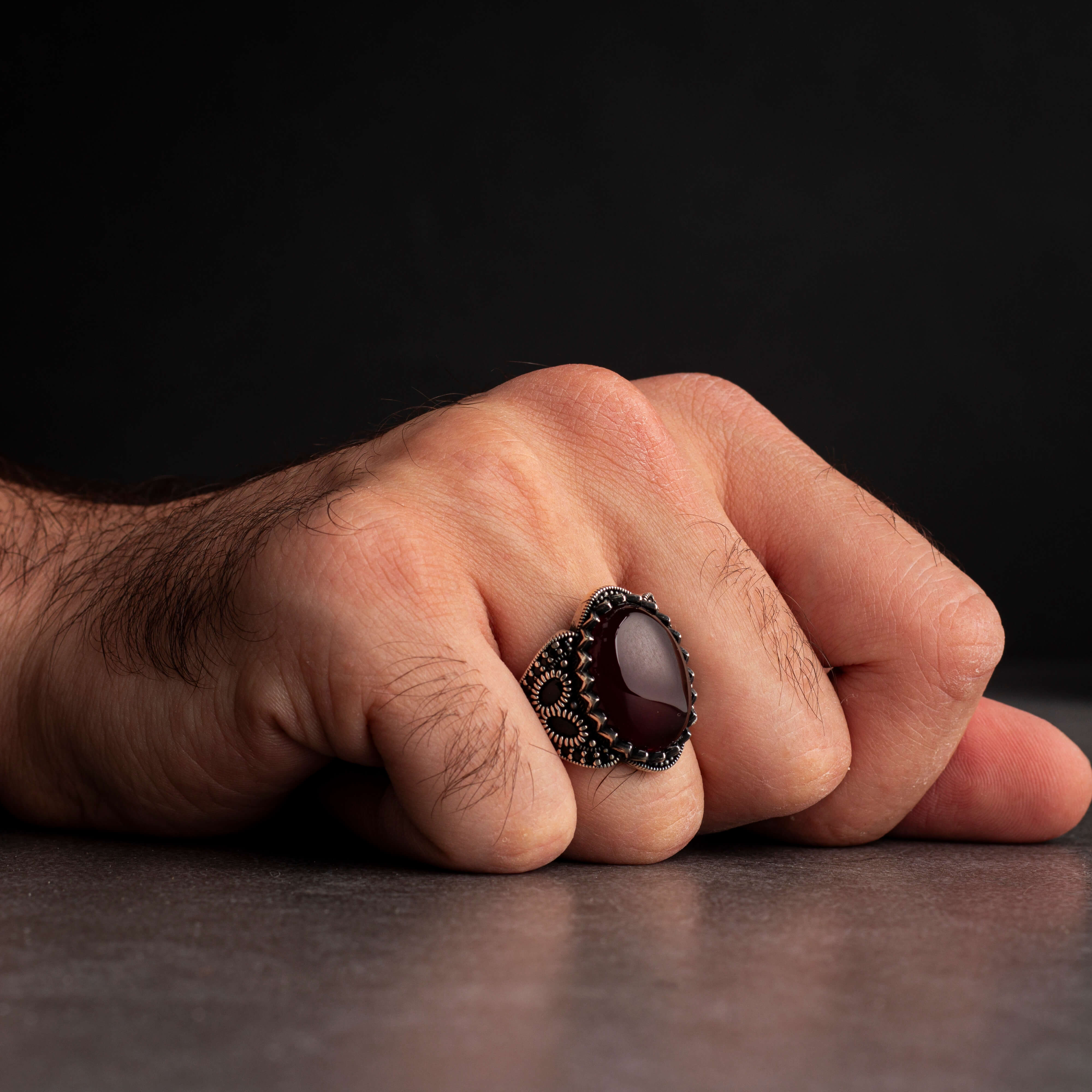 Men's silver ring decorated with a red agate stone surrounded by a geometric design