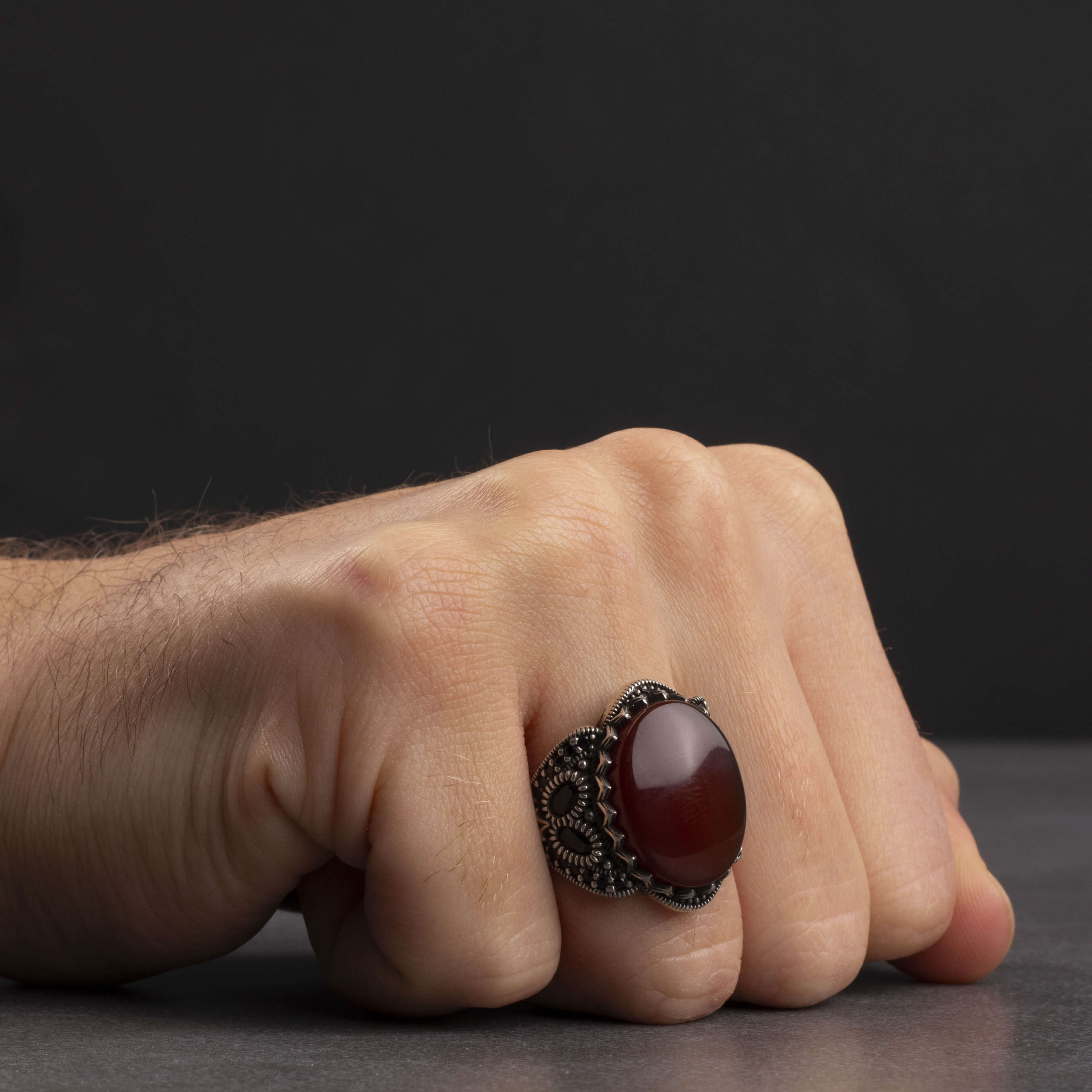 Men's silver ring decorated with a red agate stone surrounded by a geometric design